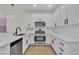Contemporary kitchen features white cabinets, stainless steel appliances, and light floors at 715 Taliput Palm Pl, Henderson, NV 89011