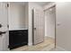 Hallway with neutral walls, wood look flooring, dark cabinets, and a doorway leading to another room at 7221 W Washington Ave, Las Vegas, NV 89128