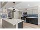 Modern kitchen with stainless steel appliances, stylish lighting, and an island that flows into dining and living areas at 7221 W Washington Ave, Las Vegas, NV 89128