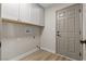 Well-organized laundry room featuring built-in cabinets and wood-look tile flooring for easy maintenance at 7221 W Washington Ave, Las Vegas, NV 89128