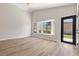 Spacious living room with wood flooring, large windows, and a black trimmed glass door to the backyard at 7221 W Washington Ave, Las Vegas, NV 89128