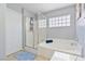 Well-lit bathroom featuring a glass-enclosed shower and a large soaking tub at 728 Twilight Blue Ave, North Las Vegas, NV 89032