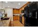Functional kitchen showcasing wood cabinets, a black appliance suite, granite countertops, and a pantry door at 759 Star Apple Ln, Las Vegas, NV 89178