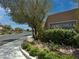 Entrance to Laurel Hills features attractive brick signage with lush landscaping, trees, and access gate at 759 Star Apple Ln, Las Vegas, NV 89178