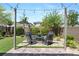 Inviting backyard with a cozy seating area, a lush green lawn, mature trees, and ambient string lights for outdoor enjoyment at 7977 Texas Hills St, Las Vegas, NV 89113