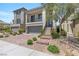 Two-story home with a two-car garage, balcony, landscaped front yard, and inviting stone walkway leading to the front door at 7977 Texas Hills St, Las Vegas, NV 89113