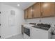 Well-organized laundry room with washer, dryer, cabinetry, and utility sink at 7977 Texas Hills St, Las Vegas, NV 89113