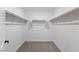 Empty walk-in closet with wall to wall rails and neutral colored carpet flooring offers an abundance of storage space at 7977 Texas Hills St, Las Vegas, NV 89113