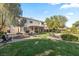 Spacious backyard featuring a covered patio, fire pit, lounge chairs, and lush green lawn at 8121 Eagle Clan Ct, Las Vegas, NV 89131