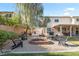 Spacious backyard with a fire pit, outdoor seating, lush greenery, and covered patio at 8121 Eagle Clan Ct, Las Vegas, NV 89131