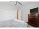 Bright bedroom includes a closet, a ceiling fan, and a dark wood dresser at 8121 Eagle Clan Ct, Las Vegas, NV 89131