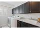 Laundry room equipped with dark cabinets, stainless steel appliances, and granite countertops at 8121 Eagle Clan Ct, Las Vegas, NV 89131