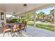Covered patio with a dining table overlooks a beautiful backyard, pool, and manicured landscaping at 8121 Eagle Clan Ct, Las Vegas, NV 89131