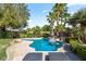 Beautiful pool and spa feature alongside lounge chairs and lush palm tree landscaping at 8121 Eagle Clan Ct, Las Vegas, NV 89131
