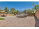 Large backyard with a trampoline, gravel landscaping, and a seating area under a bright umbrella at 8252 Pearl Oasis Ct, Las Vegas, NV 89139