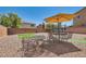 Spacious backyard with gravel landscaping, a seating area with umbrella, and a trampoline at 8252 Pearl Oasis Ct, Las Vegas, NV 89139