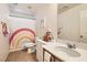 Well-lit bathroom featuring a rainbow shower curtain, marble countertop, and white cabinets at 8252 Pearl Oasis Ct, Las Vegas, NV 89139