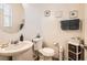 Cozy bathroom featuring a pedestal sink, toilet, decorative wall art, and accent storage cabinet at 8252 Pearl Oasis Ct, Las Vegas, NV 89139