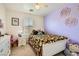 Colorful bedroom with a bed, ceiling fan, dresser and purple accent wall at 8252 Pearl Oasis Ct, Las Vegas, NV 89139