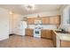 Well-lit kitchen featuring light wood cabinets, tile flooring, white appliances, and a stainless steel sink at 8252 Pearl Oasis Ct, Las Vegas, NV 89139