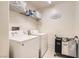 Functional laundry room with washer, dryer, storage shelf, and a decorative laundry room sign at 8252 Pearl Oasis Ct, Las Vegas, NV 89139