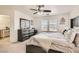 Another angle of the main bedroom featuring carpet flooring, a large dresser, and a ceiling fan at 8252 Pearl Oasis Ct, Las Vegas, NV 89139