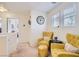 Cozy landing area with two yellow armchairs, neutral carpet, and a decorative clock at 8252 Pearl Oasis Ct, Las Vegas, NV 89139