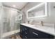 Bathroom featuring a glass enclosed shower and double sink vanity with illuminated mirror at 8700 Isola Dr, Las Vegas, NV 89117
