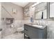 Bathroom with framed mirror, vanity, and marble-look tile wainscoting at 8700 Isola Dr, Las Vegas, NV 89117