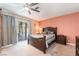 Comfortable bedroom featuring a large bed, ceiling fan, and sliding glass door to the outside patio at 8700 Isola Dr, Las Vegas, NV 89117
