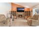 Cozy living room featuring a brick fireplace, comfortable seating, and ample natural light at 8700 Isola Dr, Las Vegas, NV 89117