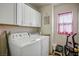 Functional laundry room featuring a washer, dryer, and ample cabinet storage for supplies at 8884 Perfect Diamond Ct, Las Vegas, NV 89129