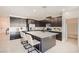 Modern kitchen features a large center island with seating and dark cabinetry at 9588 Archer Peak Ct, Las Vegas, NV 89143