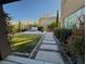 A landscaped backyard with stone pavers, manicured shrubs, and an outdoor hot tub at 9655 Skye Star Ave, Las Vegas, NV 89166
