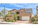 Two-story home with tan exterior, stone accents, manicured landscaping, and a two-car garage at 9655 Skye Star Ave, Las Vegas, NV 89166