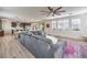 Bright, open-concept living room with modern ceiling fan, shutters on windows, and gray sectional sofa at 9655 Skye Star Ave, Las Vegas, NV 89166
