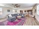 Open concept living room showcasing a plush grey sectional sofa, modern fan and access to the kitchen at 9655 Skye Star Ave, Las Vegas, NV 89166