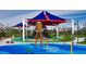 Colorful community playground with a large sunshade, water features, and green spaces at 9655 Skye Star Ave, Las Vegas, NV 89166