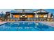 Community pool area featuring a large pool and patio seating with beautiful lighting at 9655 Skye Star Ave, Las Vegas, NV 89166