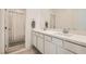 Bright bathroom featuring a double sink vanity, white cabinets, and a shower with a white curtain at 9698 Pacific Pine St, Las Vegas, NV 89143