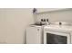Bright laundry room featuring a front loading washer and dryer set with a shelf overhead at 9698 Pacific Pine St, Las Vegas, NV 89143