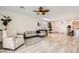 Spacious living room with modern decor, ceiling fan, and hardwood floors leading to the kitchen at 9698 Pacific Pine St, Las Vegas, NV 89143