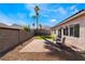 Landscaped backyard featuring a brick patio, desert landscaping, and vibrant green turf at 9705 Standard Ave, Las Vegas, NV 89129