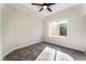 Bright bedroom with plush carpet, ceiling fan, and a large window overlooking the backyard at 9705 Standard Ave, Las Vegas, NV 89129