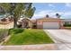 Charming single-story home featuring a well-maintained lawn, desert landscaping, and a two-car garage at 9705 Standard Ave, Las Vegas, NV 89129