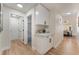 Bright hallway featuring modern white cabinets and hardware with open doorways to a bedroom and dining area at 9705 Standard Ave, Las Vegas, NV 89129