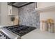 The kitchen boasts a modern range, unique backsplash, and plenty of counter space for food preparation at 9705 Standard Ave, Las Vegas, NV 89129