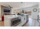 Bright open kitchen with a large island, stainless steel microwave, and sliding glass doors leading to the backyard at 9705 Standard Ave, Las Vegas, NV 89129
