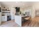 This kitchen features white cabinets, stainless appliances, a bar with seating, and an open floor plan layout at 9705 Standard Ave, Las Vegas, NV 89129