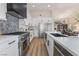 Open-concept kitchen showcases stainless steel appliances, an island with a sink, and views of the living room at 9705 Standard Ave, Las Vegas, NV 89129